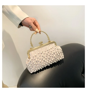 Détail du sac de soirée en satin plissé champagne avec perles et poignée en métal doré