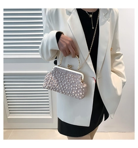 Détail de la pochette plissée lilas avec perles fantaisie et poignée en métal doré