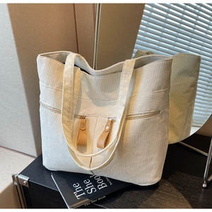 Minimalist white corduroy tote bag with dual front zipper pockets and leather pullers
