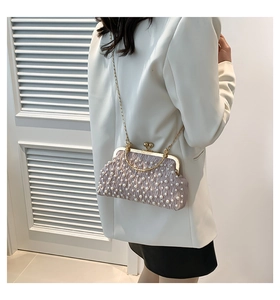 Gros plan détaillé d'un sac de soirée en satin plissé rose orné de perles blanches