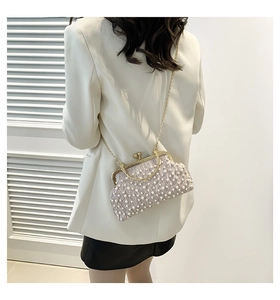 Détail de la pochette de soirée en satin rose avec perles et bandoulière dorée sur modèle