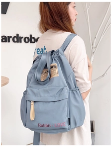 Gros plan sur le sac à dos en nylon bleu Morandi avec imprimé Rabbit Love et cordon