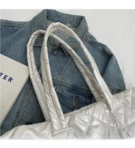 Close-up of white quilted puffer bag featuring high-shine fabric and rhombus stitching