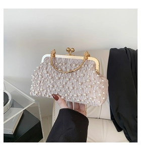 Vue détaillée du sac de soirée plissé champagne avec perles et poignée dorée