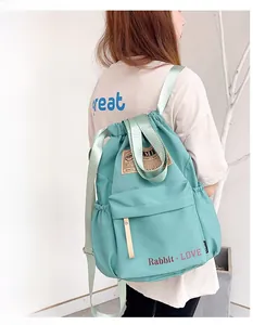 Détail d'un sac à dos en nylon vert menthe avec cordon de serrage et grande poche frontale