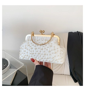 Détail du sac à main en satin blanc avec perles et poignée en métal doré élégant