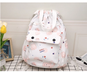 Détail du sac à dos blanc à cordon avec motifs de lapins et poche avant à rabat
