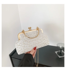 Détail du sac de soirée en satin blanc avec tissu plissé et ornements de perles denses