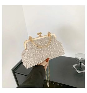 Détail des perles brodées et du fermoir boule doré vintage sur la pochette de soirée