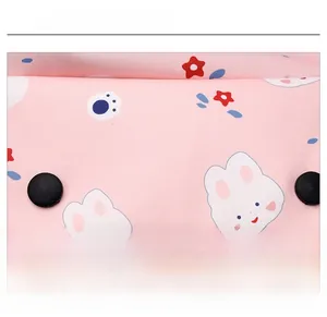 Détail du sac à dos rose à cordon avec motifs de lapins mignons et de fleurs colorées