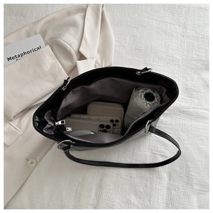 Interior view of large black leather tote bag showing spacious capacity for daily essentials