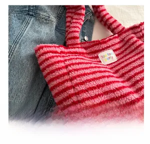 Detail van de zachte roze en rood gestreepte pluche textuur en het merklabel van de tas