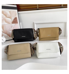Détail de sacs bandoulière en cuir grainé avec larges bandoulières en tissu rayé chic