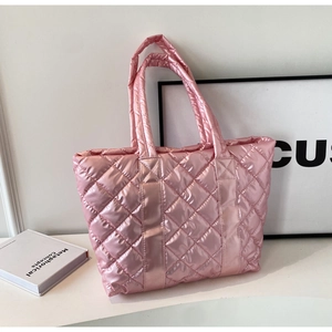 Close-up of pink metallic quilted fabric and diamond stitching on the puffer handbag