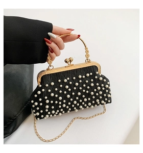 Détail d'un sac de soirée plissé noir orné de perles avec des poignées en métal doré élégant