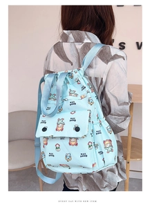 Vue détaillée du sac à dos bleu clair à cordon avec motif de fille de dessin animé mignon