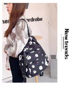 Détail d'un sac à dos noir en toile avec cordon de serrage, motif lapin et bretelles réglables
