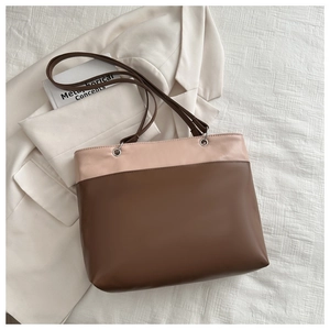 Detailed view of the dual-tone large tote bag featuring high-quality leather and metal rings