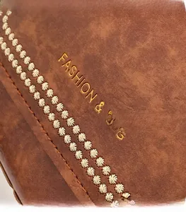 Detailed macro view of brown leather bag showing lychee texture and gold stamped logo