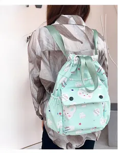 Détail du sac à dos vert menthe à cordon avec imprimés lapins et poche frontale