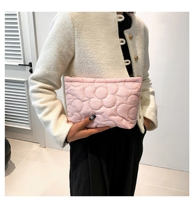 Detail of pink floral quilted polyester handbag with zipper closure and padded flower design