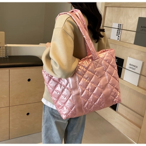 Detail of pink metallic quilted tote bag featuring glossy fabric and rhombus stitching