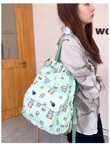 Vue détaillée du sac à dos vert menthe à cordon avec motifs de dessins animés pour école