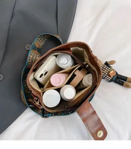 Brown PU leather crossbody bag with spacious interior compartments and ethnic print strap