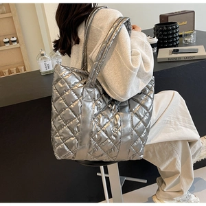 Detail of silver quilted tote bag with metallic finish and spacious shoulder strap