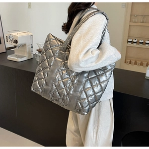 Macro shot of large silver quilted tote bag with glossy finish and diamond stitching