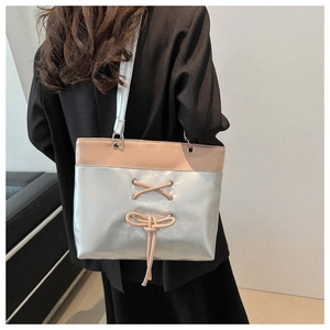 Detail showing the mixed pink and silver metallic texture with ribbon bow on tote bag