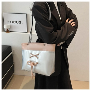 Detail of a large silver and pink tote bag with stylish lace-up crisscross decor