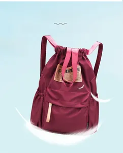 Détail macro du sac à dos en nylon bordeaux avec cordon et poids léger de 0,27 kg