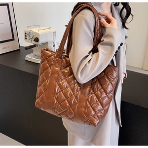 Close-up of the glossy brown quilted fabric and stitching on this winter tote bag