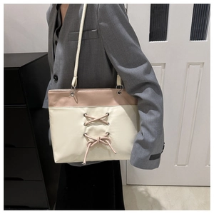 Detail of minimalist cream and dusty pink tote bag with corset-style bow detail