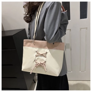 Detail view of pink and white patchwork tote bag with corset-style lace-up design