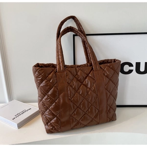 Detail view of brown quilted nylon tote bag with rhombic stitching and padded texture