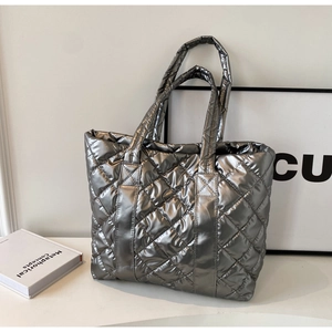 Close-up of quilted silver metallic tote bag with embroidered logo and glossy texture
