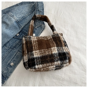 Makro-Detail einer großen braun-beigen karierten Kunstfelltasche mit weicher Textur