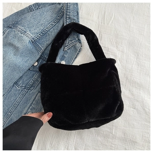 Detailansicht der schwarzen Kunstpelz-Handtasche mit Einzelgriff auf weißem Grund