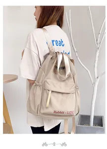 Détail du sac à dos en nylon beige avec texte Rabbit LOVE rouge et poches latérales