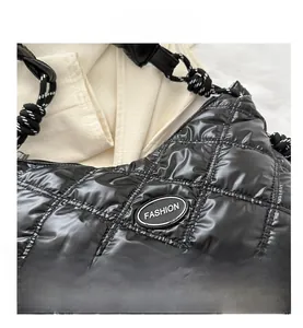 Detailed view of black puffer bag featuring quilted texture and woven rope strap