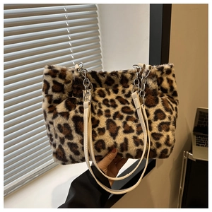 Detail of leopard print plush tote bag with white faux leather strap and metal chain