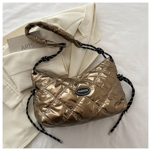 Detail of metallic quilted bag showing diamond stitching and braided rope strap texture