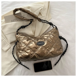 Close-up of bronze quilted puffer bag with glossy finish and rope drawstring detail