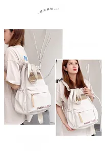 Vue détaillée du sac à dos blanc en nylon avec une poche latérale pratique à cordon