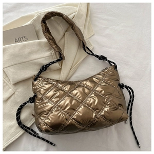 Close-up of metallic quilted puffer bag with bronze finish and contrast drawstrings