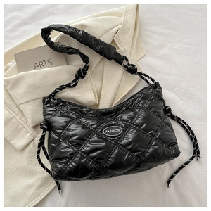 Detail of black glossy quilted shoulder bag with fashion label and rope strap