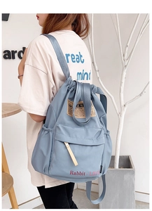 Détail du sac à dos bleu morandi avec cordon de serrage, imprimé Rabbit LOVE et poche zippée