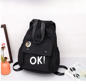 Dettaglio dello zaino Oxford nero con stampa bianca OK e stemma decorativo a scimmia